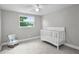 Bright bedroom with neutral colors, natural light from the window, ceiling fan, and rocking chair at 3721 Casaba Loop, Valrico, FL 33596