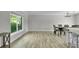 Spacious dining room with wood-look floors, view of backyard and access to the kitchen area at 3721 Casaba Loop, Valrico, FL 33596