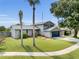 Charming home featuring a well-manicured lawn and mature palm trees, creating a welcoming curb appeal at 3721 Casaba Loop, Valrico, FL 33596