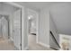 Hallway with open doorways leading to bedrooms and an open staircase at 3721 Casaba Loop, Valrico, FL 33596