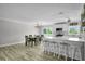 Bright, open kitchen featuring an island with bar seating, stainless steel appliances, and an adjacent dining area at 3721 Casaba Loop, Valrico, FL 33596