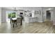Open-concept kitchen and dining area with modern white cabinetry, stainless steel appliances, and stylish lighting at 3721 Casaba Loop, Valrico, FL 33596