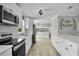 Well-lit kitchen featuring stainless steel appliances, white cabinetry, and seamless access to other living spaces at 3721 Casaba Loop, Valrico, FL 33596