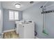 Convenient laundry room with modern washer and dryer, storage shelf, and window at 3721 Casaba Loop, Valrico, FL 33596