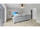 Bright living room features a gray sofa, ceiling fan, and stylish laminate flooring at 3721 Casaba Loop, Valrico, FL 33596