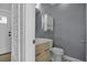 Stylish powder room with modern vanity, round mirror, and beadboard accent wall at 3721 Casaba Loop, Valrico, FL 33596