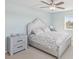 Light-filled bedroom with ceiling fan, carpet, neutral color palette and large bed at 400 64Th Ave # 202, St Pete Beach, FL 33706