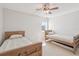 Neutral bedroom with two twin beds, carpet, ceiling fan, and a bright window at 400 64Th Ave # 202, St Pete Beach, FL 33706