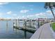 View of boat dock featuring multiple boat lifts, manicured lawn, and clear blue sky at 400 64Th Ave # 202, St Pete Beach, FL 33706