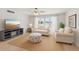 Cozy living room with a comfortable sofa, a beach-themed ottoman, and a TV set at 400 64Th Ave # 202, St Pete Beach, FL 33706