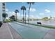 View of outdoor shuffleboard courts in a landscaped area with water in the background on a sunny day with some clouds at 400 64Th Ave # 202, St Pete Beach, FL 33706