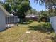Fenced backyard with a shed, small plants and trees, with a screened patio on the left at 4707 Barrett Ct, Tampa, FL 33617