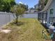 Spacious backyard features a tall, thin tree, white fence, a screened in patio, and equipment at 4707 Barrett Ct, Tampa, FL 33617