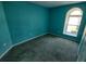 Serene bedroom with aqua walls and a unique arched window, creating a peaceful retreat at 4707 Barrett Ct, Tampa, FL 33617