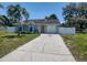 Well-maintained single-story home with arched windows, yellow door, attached garage, and concrete driveway at 4707 Barrett Ct, Tampa, FL 33617