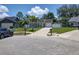 View of the house on the street with a well-maintained lawn, mature trees, and blue car parked nearby at 4707 Barrett Ct, Tampa, FL 33617