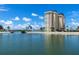 Waterfront condo building with scenic water view, complemented by palm trees and lush greenery for tropical experience at 4775 Cove Cir # 803, St Petersburg, FL 33708