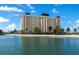 Waterfront condo building view from across the water, showcasing architectural design with tranquil waterfront setting at 4775 Cove Cir # 803, St Petersburg, FL 33708