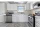 Cozy kitchen features white cabinets, stainless steel appliances, and a bright window over the sink area at 4775 Cove Cir # 803, St Petersburg, FL 33708