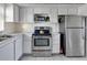 Functional kitchen features white cabinetry, stainless steel appliances, and tiled backsplash at 4775 Cove Cir # 803, St Petersburg, FL 33708