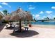 Outdoor seating area with thatched umbrellas and waterfront views, offering a relaxing and shaded lounge space at 4775 Cove Cir # 803, St Petersburg, FL 33708