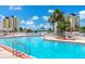 A community pool surrounded by lush landscaping and multiple lounge chairs at 4775 Cove Cir # 803, St Petersburg, FL 33708