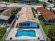 Aerial view of home with tiled roof and fenced yard with a pool in a residential neighborhood at 4849 Floramar Ter, New Port Richey, FL 34652