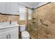 Bathroom featuring tile walls, glass enclosed shower, toilet, and vanity with sink at 4849 Floramar Ter, New Port Richey, FL 34652