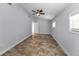 Bright bedroom with tile flooring features a ceiling fan, a window, and a white interior door at 4849 Floramar Ter, New Port Richey, FL 34652