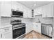Modern kitchen featuring stainless steel appliances, white cabinets, and quartz countertops at 4849 Floramar Ter, New Port Richey, FL 34652