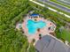 Aerial view showcasing community pool amenities, with a relaxing pool, patio area, and lush tropical landscaping at 4906 Los Robles Ct, Palmetto, FL 34221