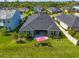 Aerial view displays a home's backyard with patio, seating, lush lawn, landscaping and view of neighboring properties at 4906 Los Robles Ct, Palmetto, FL 34221