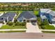 Aerial view of a home with a well-manicured lawn, two-car garage, and a dark roof at 4906 Los Robles Ct, Palmetto, FL 34221