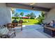 Cozy covered back patio with outdoor furniture, grill, and a view of the spacious backyard at 4906 Los Robles Ct, Palmetto, FL 34221