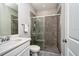 Bathroom with a stylish shower featuring gray marble tile, complemented by a sink and white cabinets at 4906 Los Robles Ct, Palmetto, FL 34221