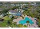 Aerial view showcases a beautiful clubhouse and an inviting community pool surrounded by lush landscaping at 4906 Los Robles Ct, Palmetto, FL 34221