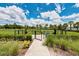 Community dog park featuring manicured lawns, mature landscaping, and secure fencing with gated entrance for resident's pets at 4906 Los Robles Ct, Palmetto, FL 34221