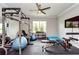 Well-equipped exercise room with weight rack, machines, large television and fan at 4906 Los Robles Ct, Palmetto, FL 34221