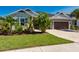 Inviting single-Gathering home showcasing meticulous landscaping, a well-kept lawn, and attached two-car garage at 4906 Los Robles Ct, Palmetto, FL 34221