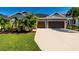 Beautiful home with a two-car garage, well-manicured lawn and tropical landscaping at 4906 Los Robles Ct, Palmetto, FL 34221