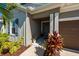 Inviting front entrance with decorative plants, dark front door, and a well-lit porch at 4906 Los Robles Ct, Palmetto, FL 34221