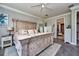 Spacious main bedroom featuring a decorative wood-paneled bed, ceiling fan, and ensuite access at 4906 Los Robles Ct, Palmetto, FL 34221