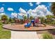 Community playground with a colorful slide, climbing structure and pirate ship in a tropical setting at 4906 Los Robles Ct, Palmetto, FL 34221