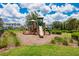 Community playground featuring a wood structure, slide, and swingset in a well-maintained grassy area with trees at 4906 Los Robles Ct, Palmetto, FL 34221