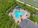 A beautiful shaped pool with a hot tub and lots of lounge chairs around it and palm trees at 4906 Los Robles Ct, Palmetto, FL 34221