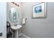 Powder room featuring a pedestal sink, decorative mirror, and a framed artwork on the wall at 4906 Los Robles Ct, Palmetto, FL 34221