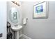 Bright powder room featuring pedestal sink, decorative mirror and fresh white towel at 4906 Los Robles Ct, Palmetto, FL 34221