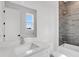 Bright bathroom featuring a white vanity with marble countertop, tub, and stylish gray tiled shower at 50 64Th S St, St Petersburg, FL 33707
