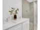 Bathroom with double sinks, quartz countertop, modern fixtures, and a glass-enclosed shower at 50 64Th S St, St Petersburg, FL 33707