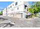 Modern townhome featuring a tandem two car garage, clean white stucco, and lush landscaping at 50 64Th S St, St Petersburg, FL 33707
